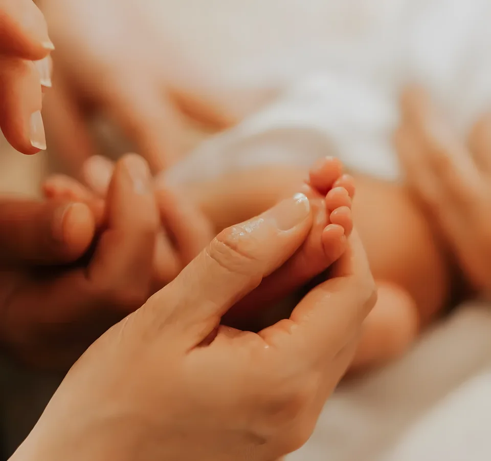 Réflexologie plantaire bébé : doigts massant le pied d’un nourrisson