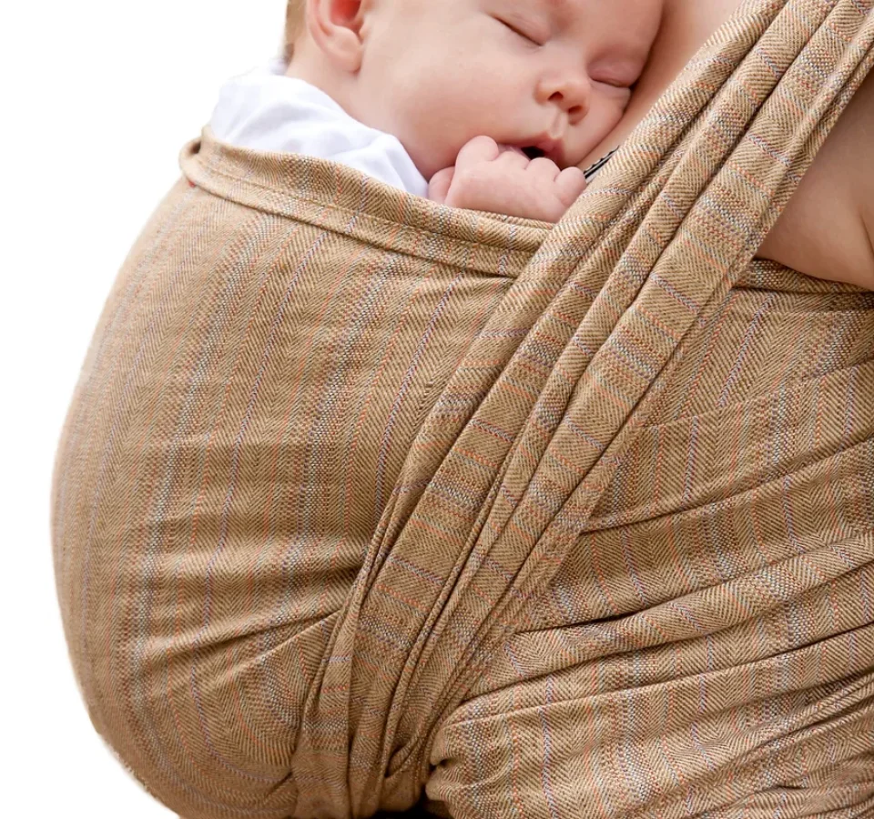Bébé endormi en écharpe de portage physiologique contre son parent