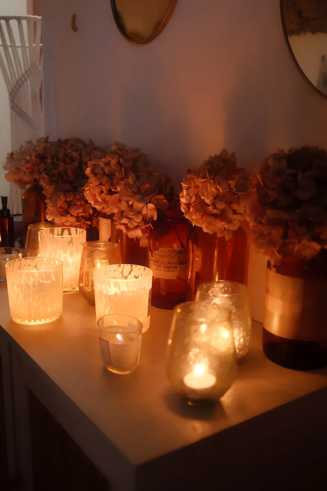Bougies allumées et hortensias séchés dans la salle de soin Mon Premier Souffle