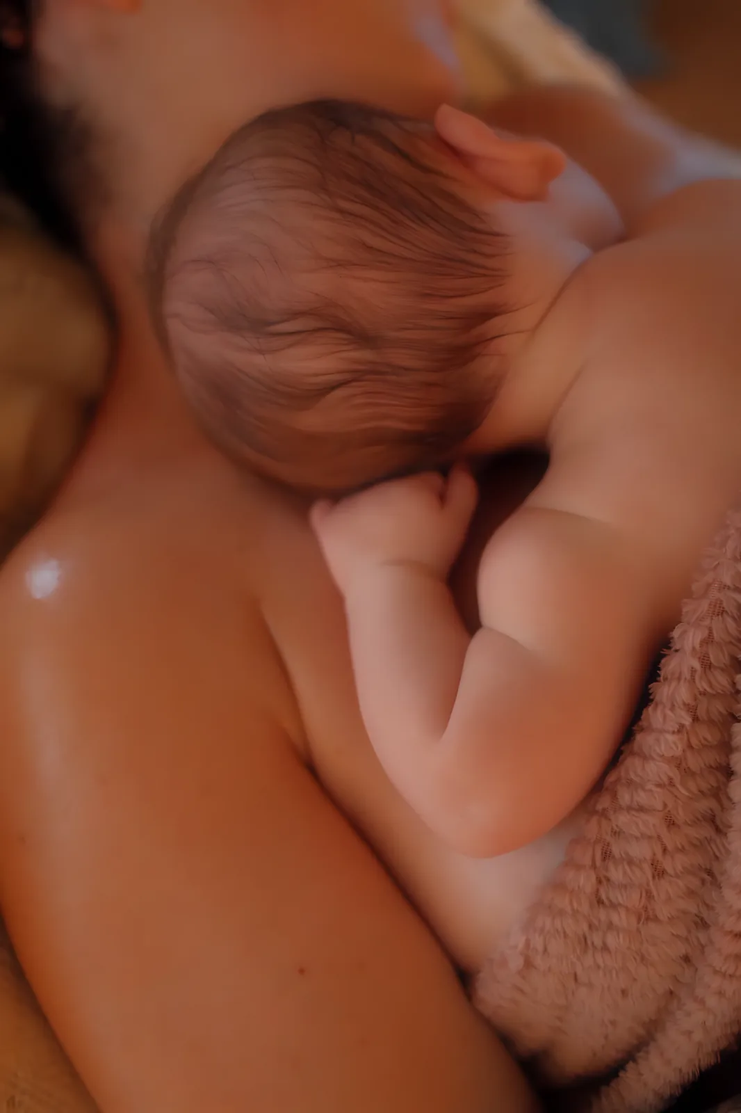 Nouveau-né blotti en peau à peau contre l’épaule de sa maman