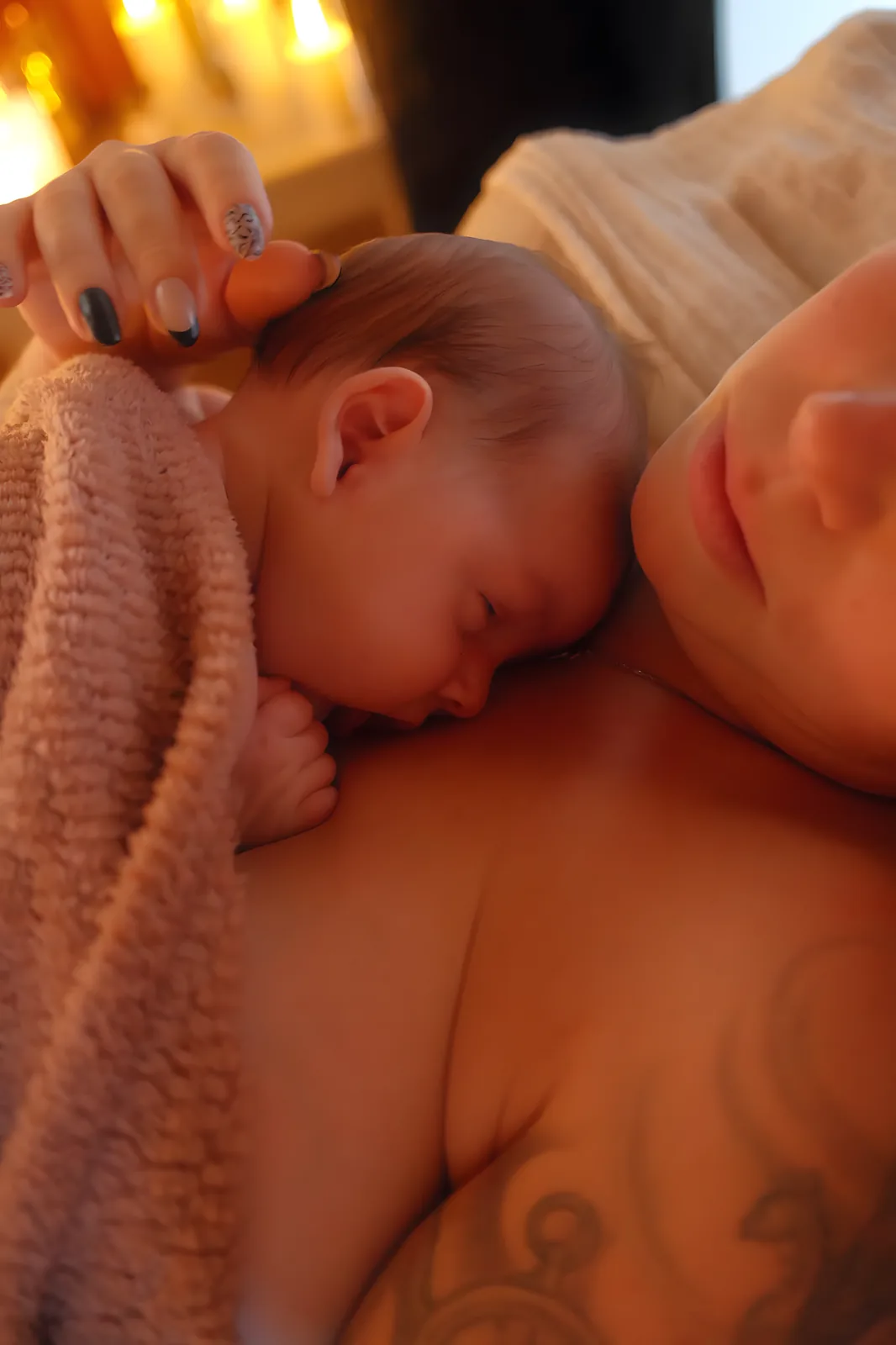 Main de la maman caressant la tête de son bébé endormi en peau à peau